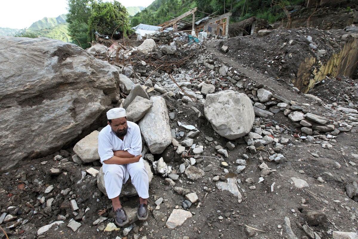 A man in front of the ruins of his house after the flood disaster, Kokarai, Pakistan