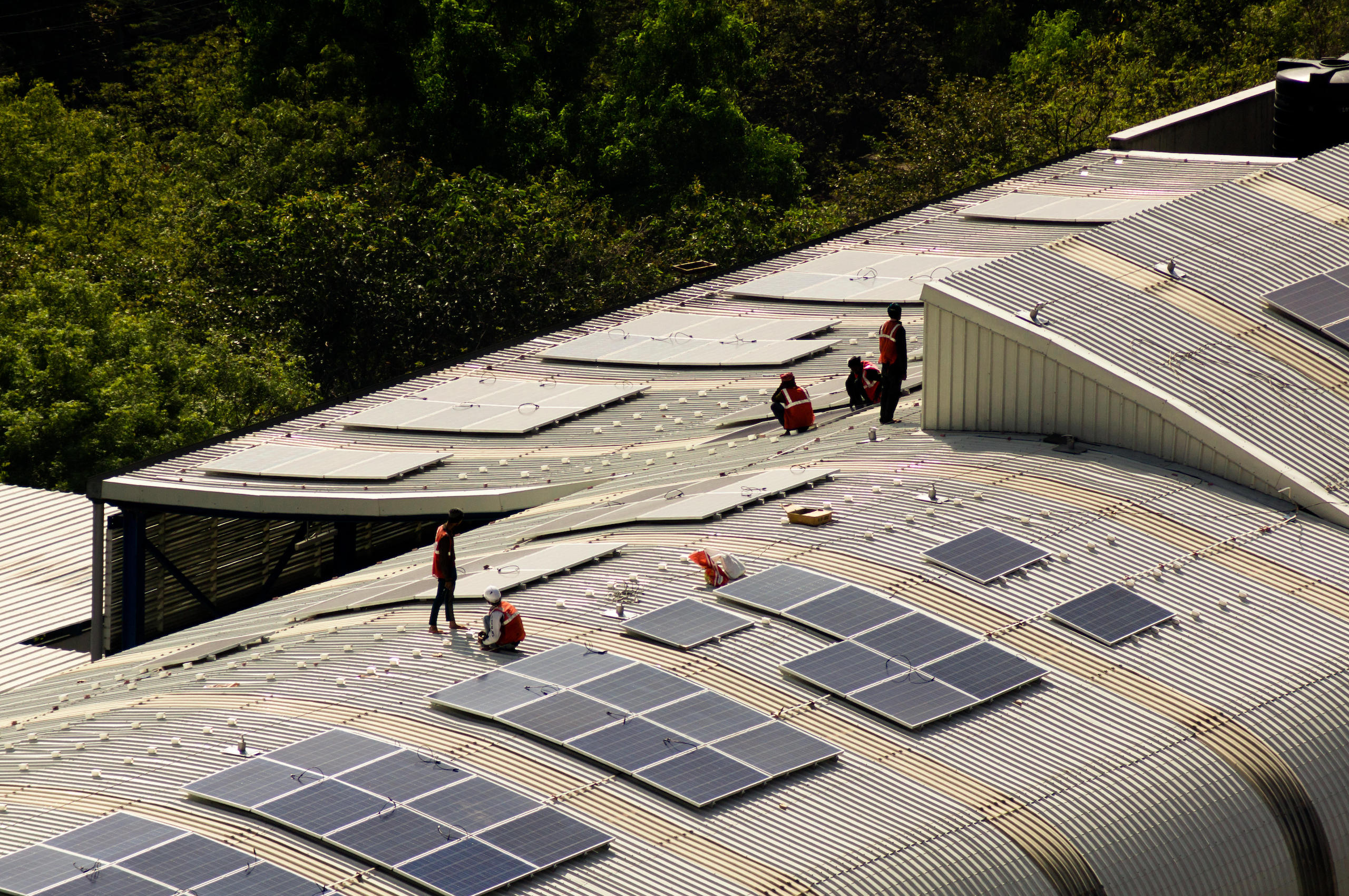 <p>Workers install solar panels on the roof of a metro station in Noida, Delhi, in January 2019 (Amlan Mathur / Alamy)</p>