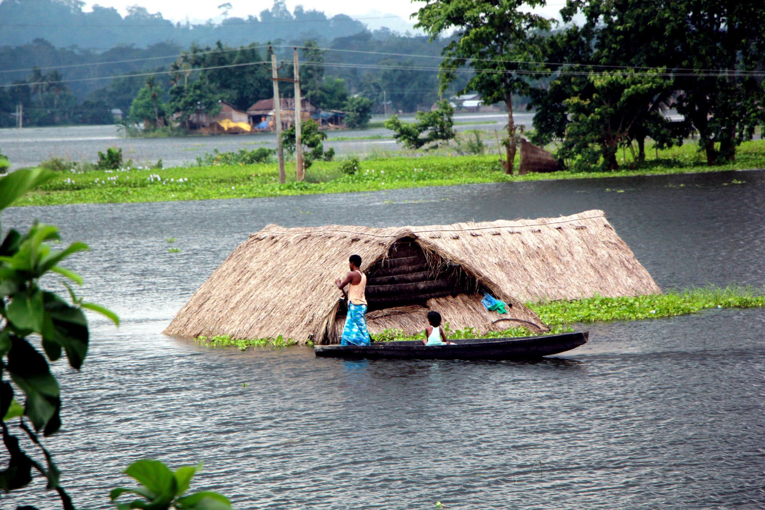 <p>Flood victim moves towards safe land as their house submerged in flood water (Image: Simanta Talukdar / Pacific Press / Alamy Live News)</p>