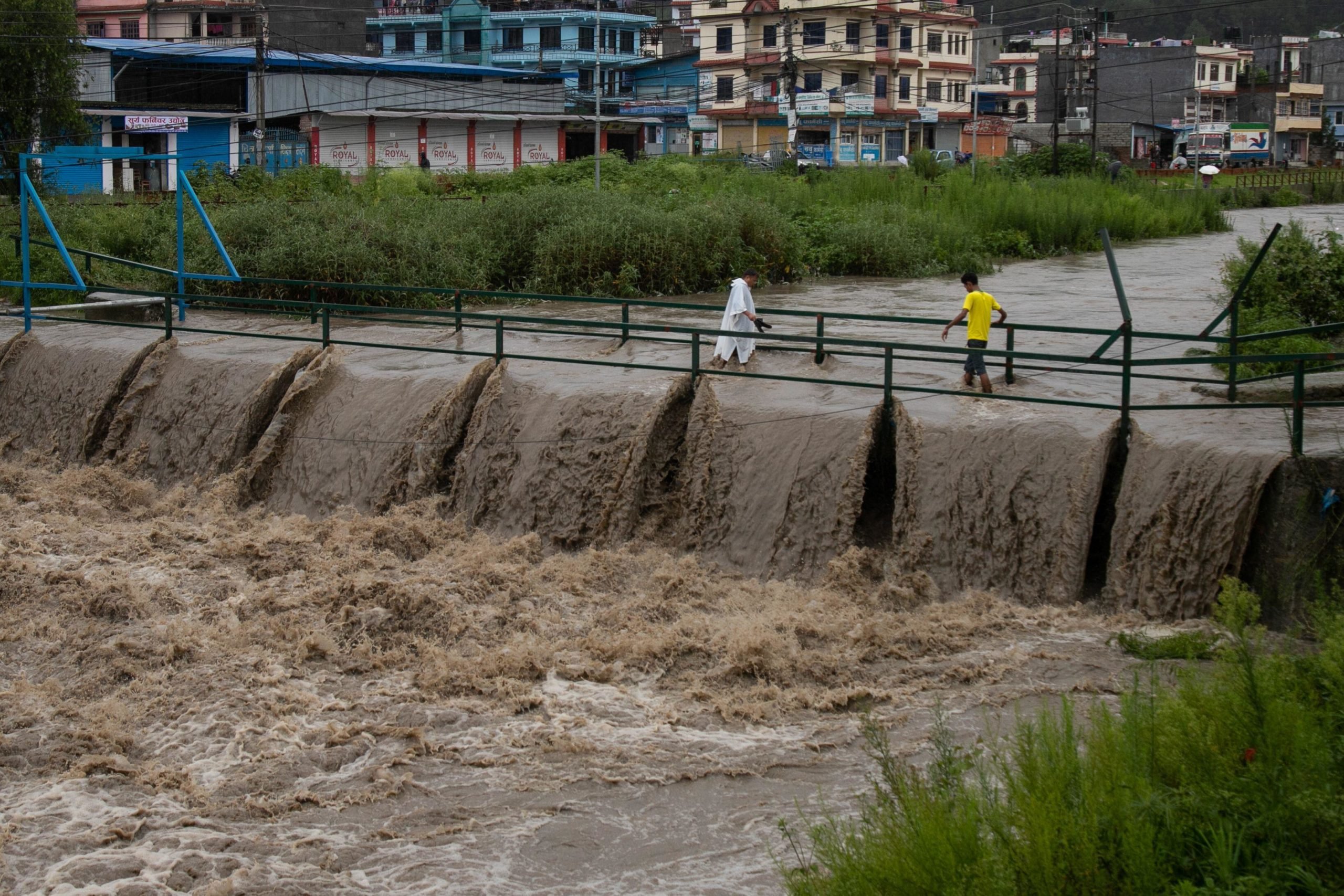 People cross a bridge during a flood in Kathmandu, Nepal