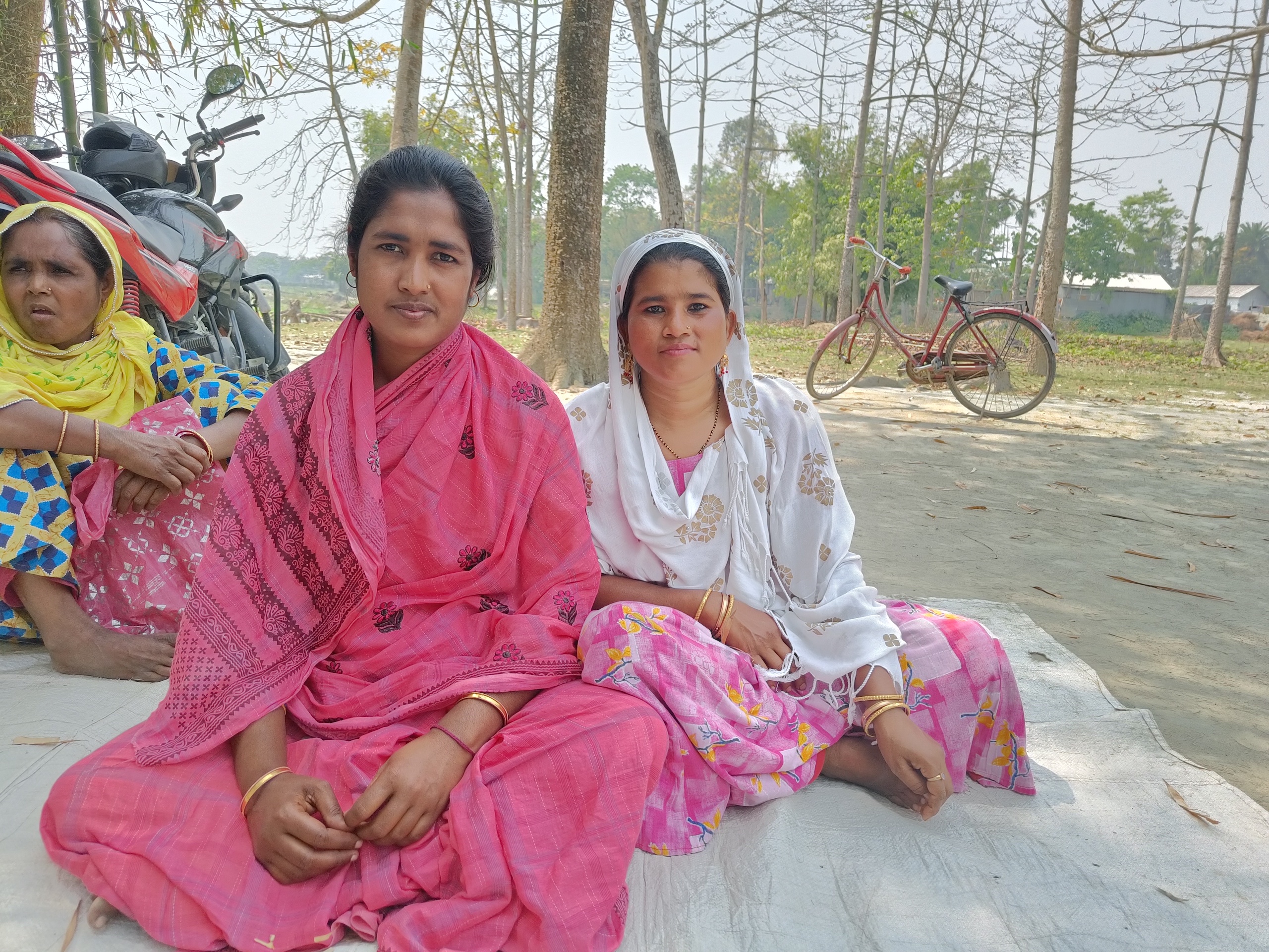 <p>Inawara Khatun (centre) and her family choose to stay in the village of Rupakuchi in Assam, despite the financial hardships and emotional distress brought by flooding. She says migrating would meaning losing the social relationships and networks that help her survive in the aftermath of disasters. (Image: Aatreyee Dhar)</p>