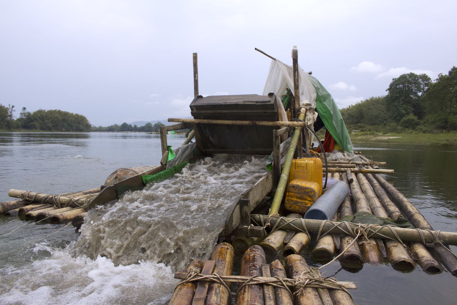A mining vessel on the Mali River in Kachin State. Sediment suctioned from the river bottom passes through a sluice tray before mercury is added to extract gold.