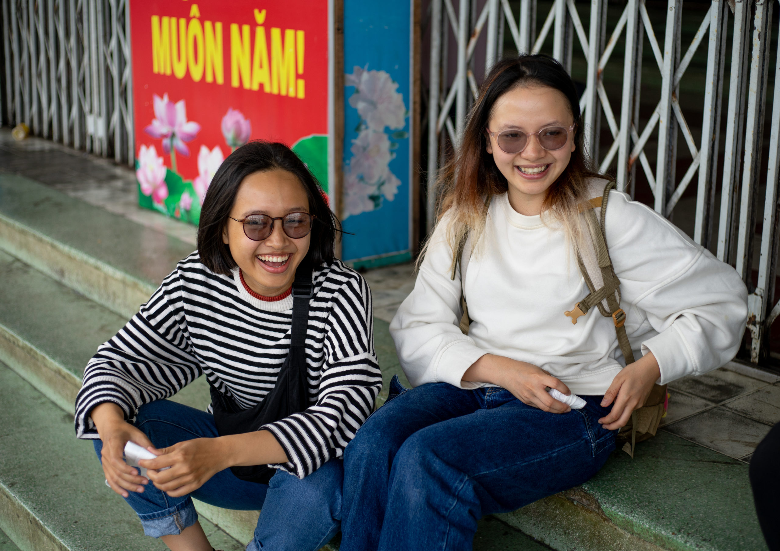 two smiling women sitting on steps