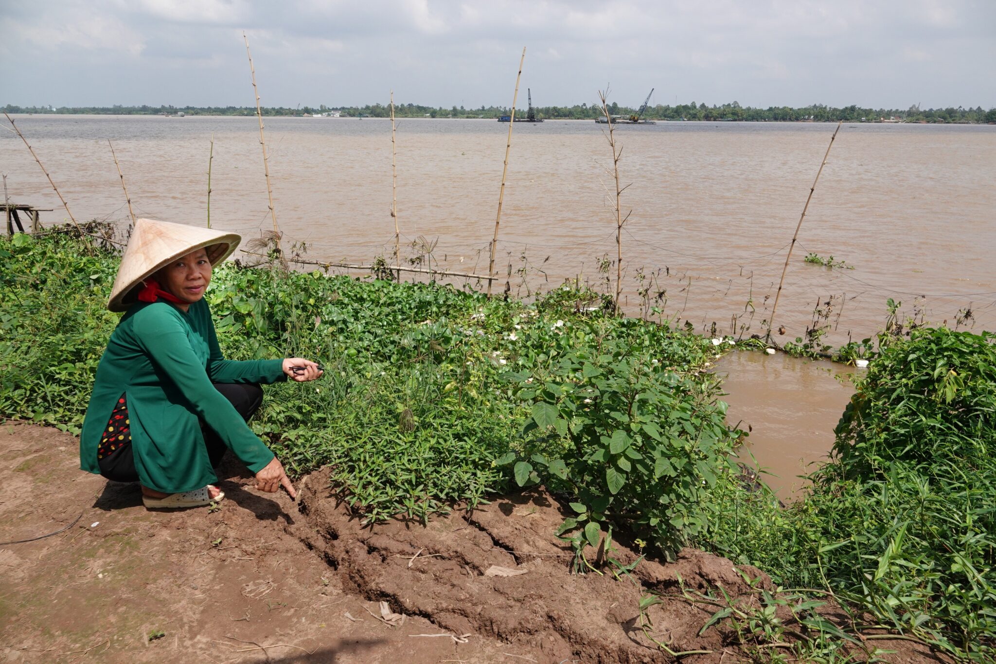 Phan Thi Kim Ngan, 57, points at signs of erosion on Son islet