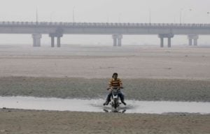 Man drives a motorbike on a dry riverbed