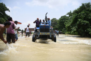 <p>People use a tractor to navigate floodwaters in Muzaffarpur district, in India’s Bihar state, in 2020 (Image: Sachin Kumar)</p>