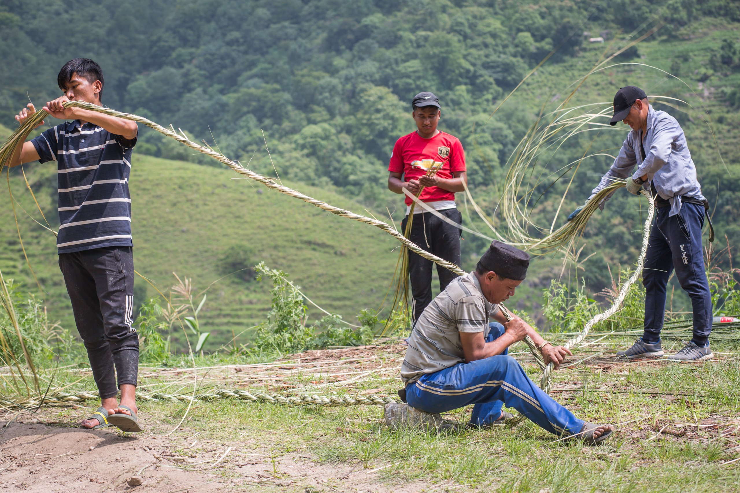 ) The group twist the bamboo strips into parang rope, which is then fixed with wooden rungs to make the hunting ladder