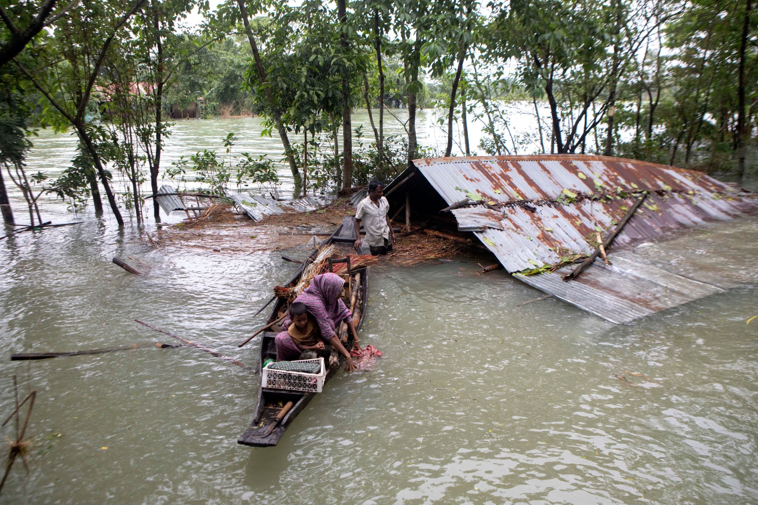 A family flees a flood-affected area by boat
