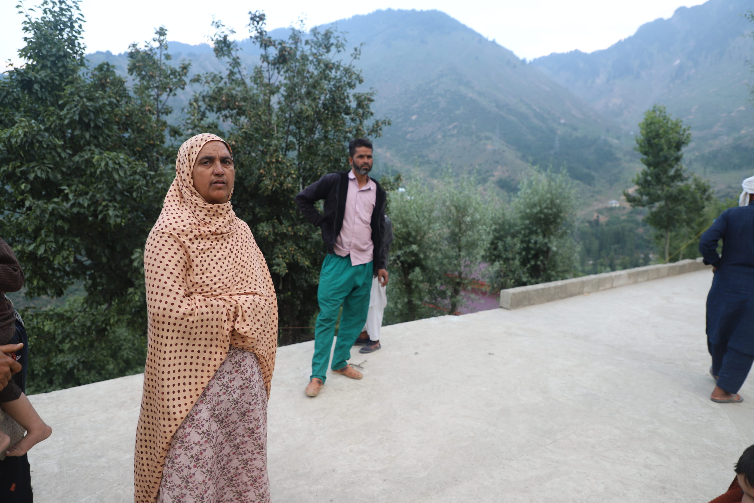 people on a paved road in hilly area