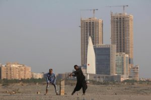 <p>People play cricket on Sea View beach in Karachi, with the Hyperstar shopping mall and under-construction buildings in the background. Just along the coast from here is Phase 8 – a huge development being carried out by Pakistan’s military housing authority. (Image: Akhtar Soomro / Alamy)</p>
