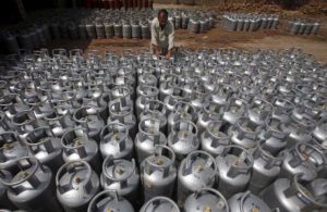 A worker carries a cylinder of Liquified Petroleum Gas (LPG) at a gas distribution centre in Peshawar, Pakistan