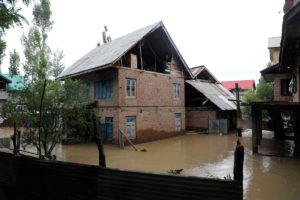 <p>In late June, water from the Jhelum River overflowed its banks, triggering flood alerts in Kashmir and forcing people to seek safety in the upper storeys of their homes (Image: Umer Asif)</p>
