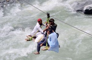 <p>People cross the Swat River after flash floods in Swat, northwest Pakistan, on 5 September 2022. Climate scientists say that while this year’s catastrophic flooding across the country has been compounded by flash flooding in some northern districts, it occurred mainly because of torrential monsoon rains in Sindh and Balochistan, in the south of the country. (Image: Saeed Ahmad / Alamy)</p>