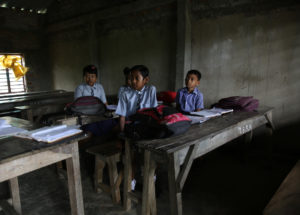 Schoolboys at their desks in a mostly empty classroom