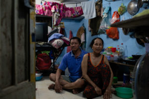 couple sitting on floor of cluttered room