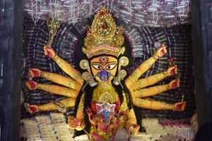 depiction of Goddess Durga surrounded by plastic bottles and wearing a mask