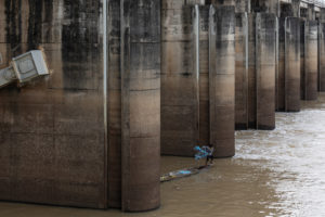 <p>A fisher casts his net in the shadow of the Hua Na dam on Thailand’s Mun River (Image: <a href="https://www.lukeduggleby.com/">Luke Duggleby</a> / The Third Pole)</p>