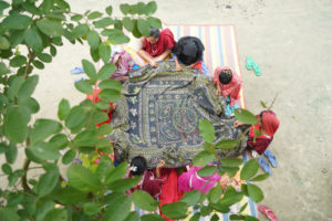 group of women stitching embroidery onto black cloth