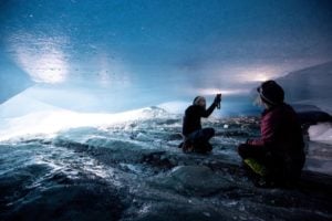 Glaciologists with torches inspect a crack in the ceiling of a natural glacier cavity of the Jamtalferner glacier in Austria.