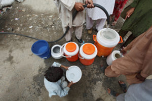 overhead view of people standing over large water containers