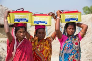 <p>पश्चिम बंगाल में सुंदरबन के एक द्वीप पर सौर ऊर्जा से चलने वाली बैटरी इकट्ठा करती महिलाएं (फोटो: एशले कूपर / अलामी)</p>