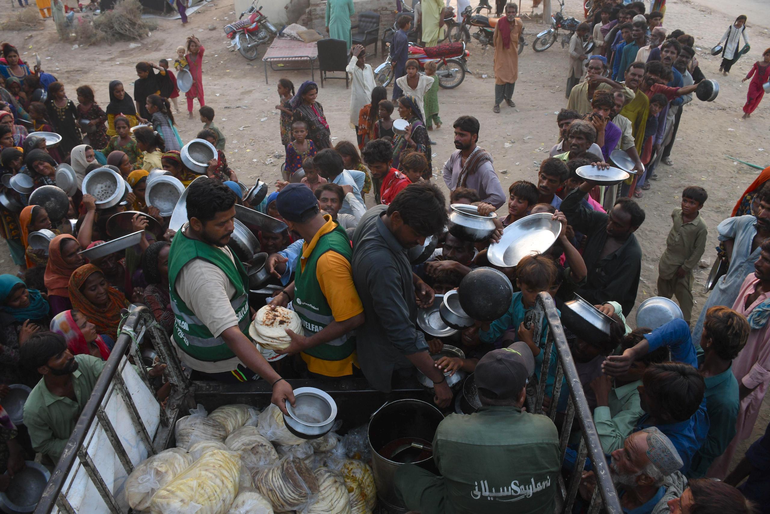 People affected by floods receive free food in flooded areas in Pakistan