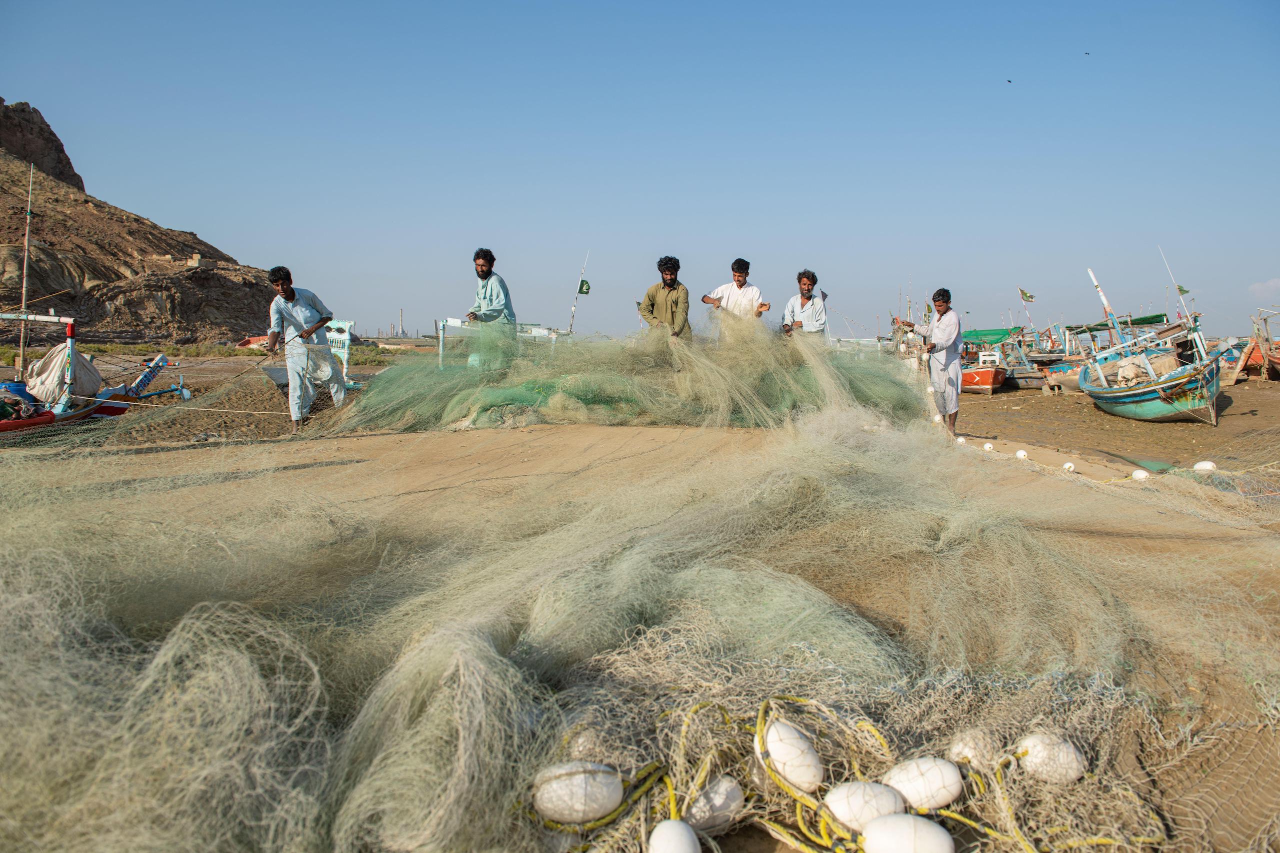 Group of fisherman preparing a gillnet fishing net near Karachi, Pakistan