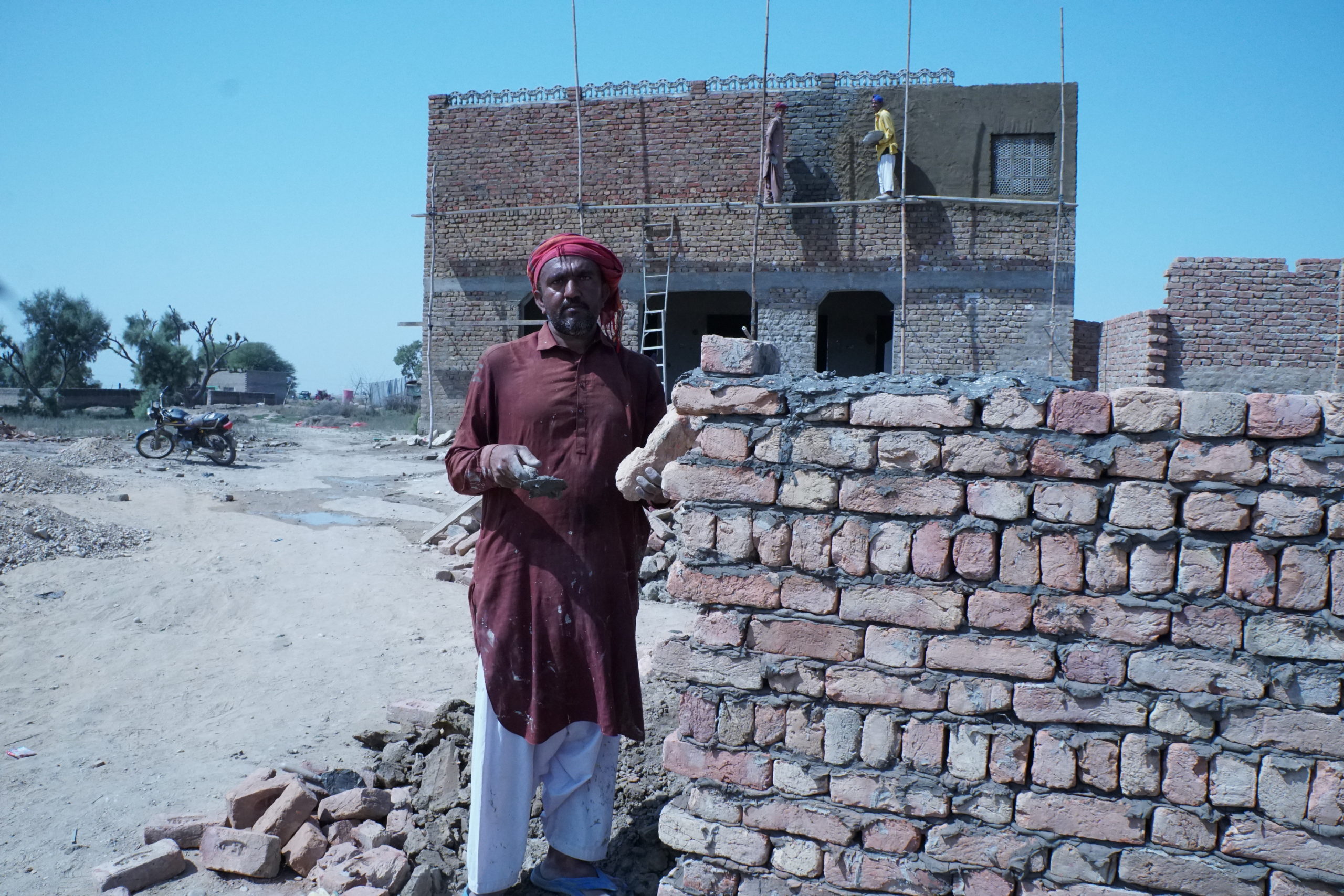 man standing next to brick wall