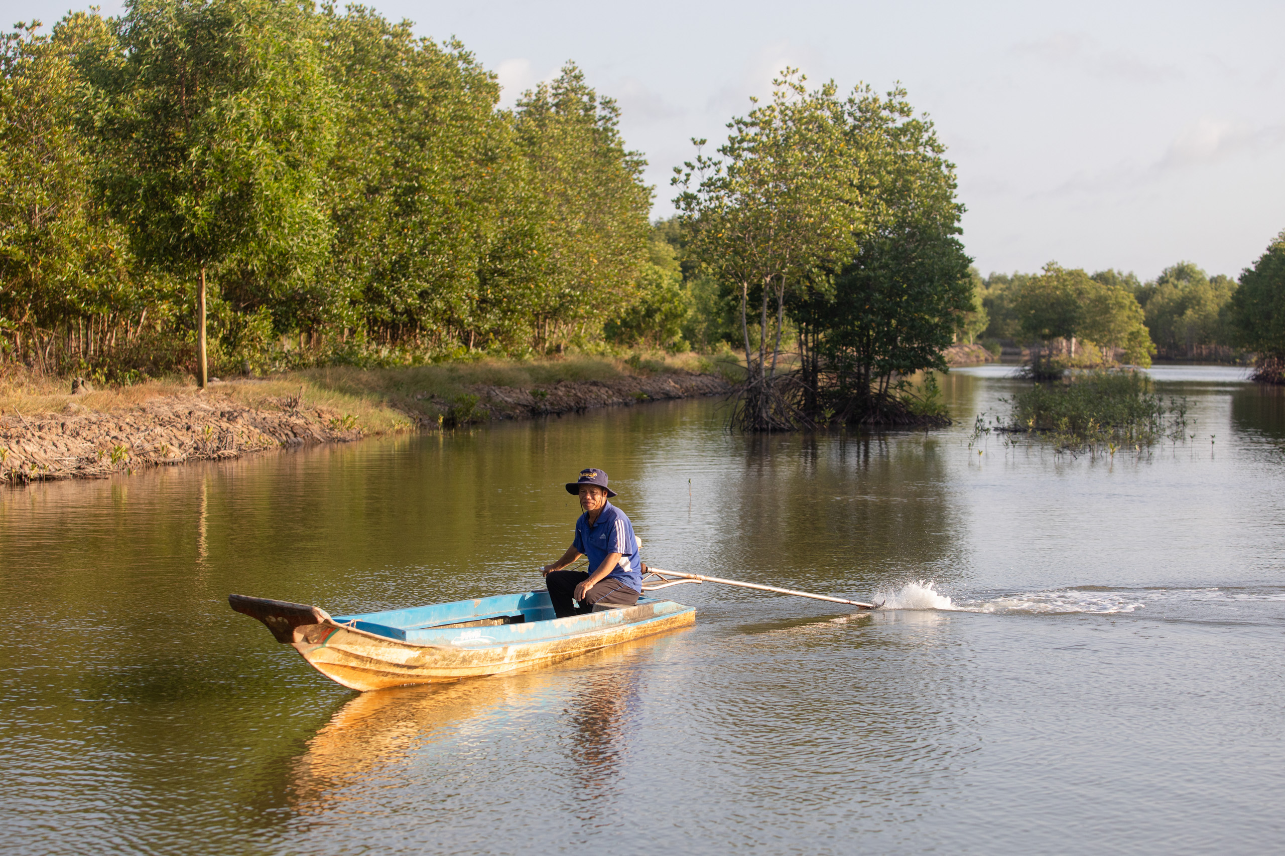 Nam Dzung circling his 8-ha pond by boat in Vien An Commune, Ngoc Hien, Ca Mau provine, Vietnam.