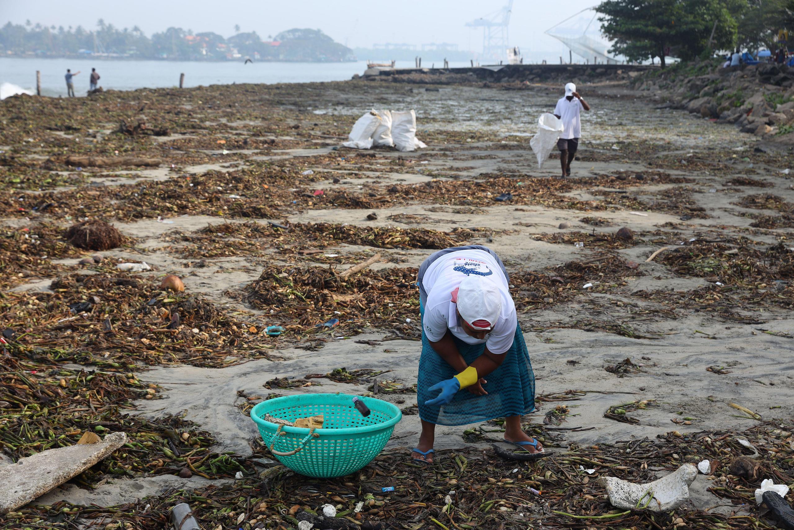 Workers pick waste plastic from the Arabian Sea in Fort Kochi, Kerala.