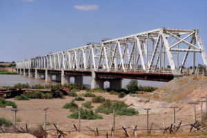 Friendship bridge going over river onto arid land