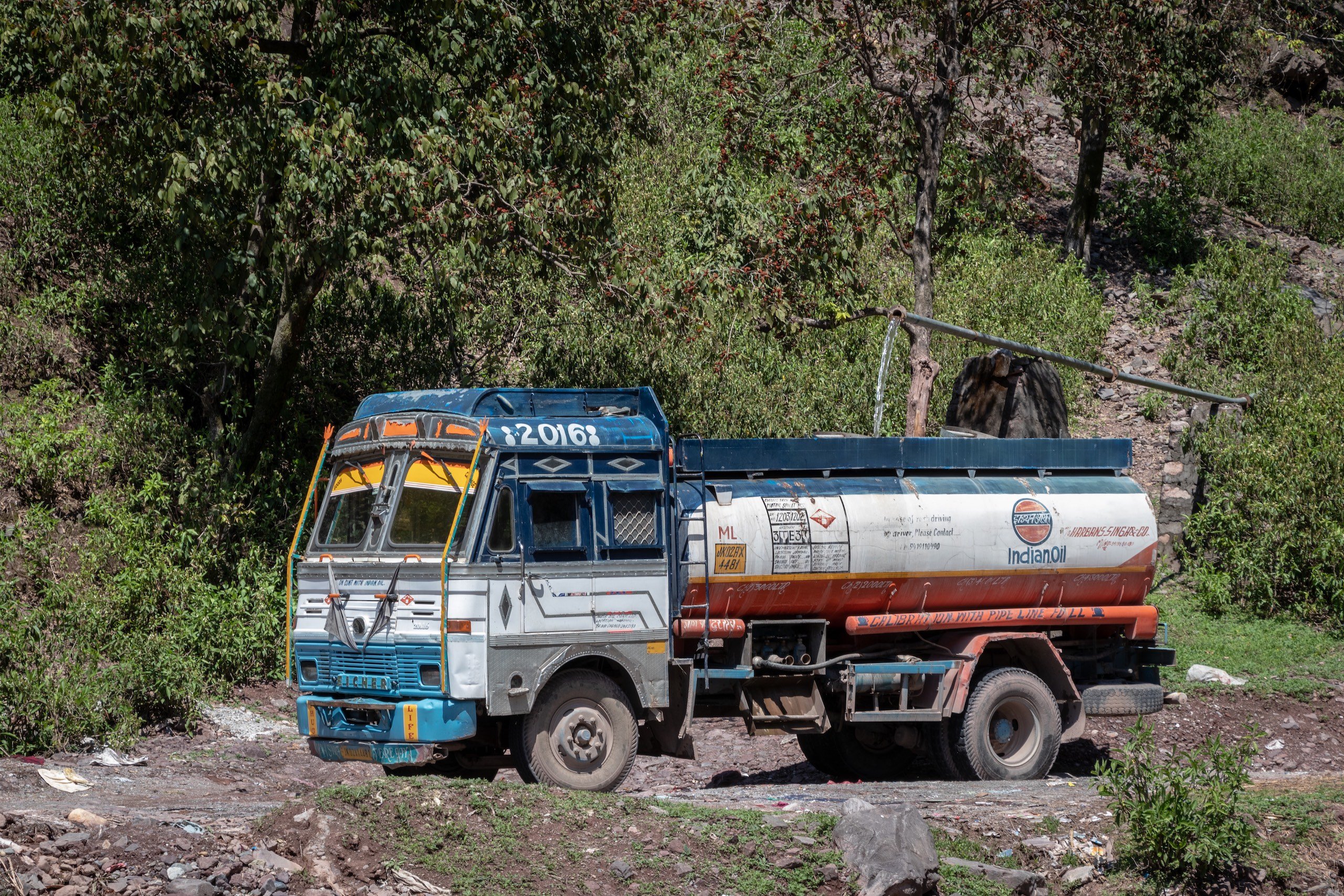A tanker being filled with water from a spring to be transported in surrounding villages of Reasi 