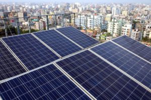 Rooftop solar panels, against a backdrop of mid rise buildings in urban Bangladesh,