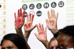 hands painted with red to signify blood at cop27 climate change conference