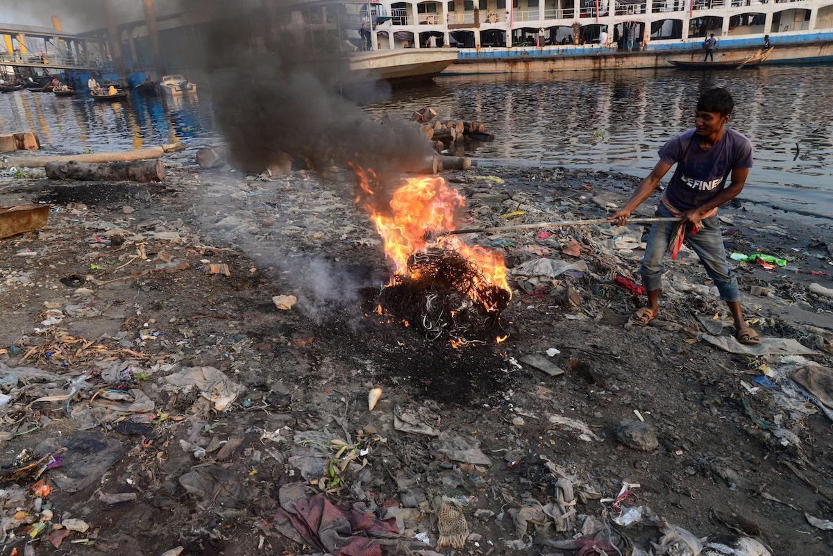 A man burning garbage in Dhaka, Bangladesh