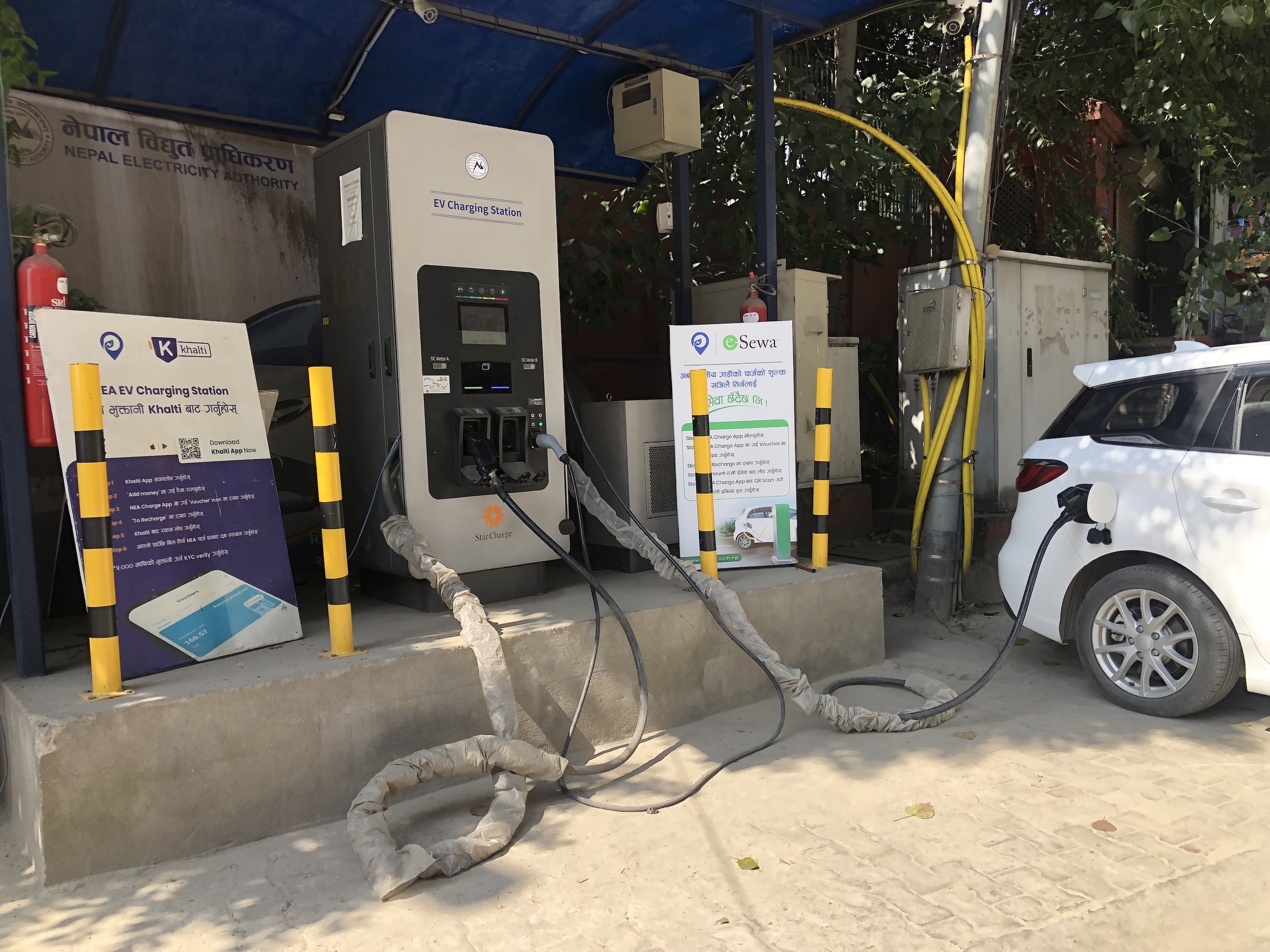 A white car plugged into an electric vehicle (EV) charging station