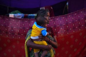 <p>A woman and her child who had been relocated to a makeshift camp in July 2023, after the Yamuna River overflowed due to heavy monsoon rainfall (Image: Shivam Khannai / Alamy)</p>