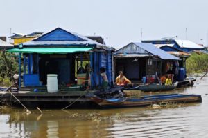<p>Residents of floating villages near the banks of Tonle Sap Lake rest on wooden decks. They say they have seen fish stocks decline as a result of poor water quality and overfishing in the lake. (Image: Sokom Kong)</p>