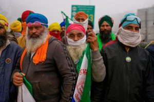 group of men wearing turbans and holding protest banners